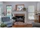 Cozy living room with brick fireplace, decorative windows, and hardwood floors at 192 Adelaide Xing, Acworth, GA 30101