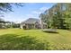 An expansive backyard with green grass and treeline behind a beautiful home at 220 Rocky Point Rd, Covington, GA 30014