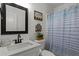 Clean bathroom with a vanity, mirror, toilet, and shower with a blue and white striped curtain at 220 Rocky Point Rd, Covington, GA 30014