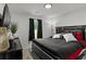 Modern bedroom with a black bed, black dresser, and a TV mounted on the wall at 220 Rocky Point Rd, Covington, GA 30014