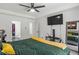 Bright bedroom featuring a ceiling fan and a modern TV mounted on the wall at 220 Rocky Point Rd, Covington, GA 30014