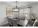 Formal dining room with modern chandelier, a wooden table, and comfortable upholstered chairs at 220 Rocky Point Rd, Covington, GA 30014