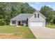 Inviting single-story house with a two-car garage, shutters, and a well-manicured front lawn at 220 Rocky Point Rd, Covington, GA 30014