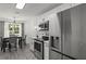 Bright kitchen with stainless steel appliances, white cabinets, and a dining area at 220 Rocky Point Rd, Covington, GA 30014