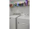 Functional laundry room with stacked washer and dryer, and ample storage space on the shelf at 220 Rocky Point Rd, Covington, GA 30014