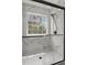 Elegant glass shower with marble-patterned walls and a window with views of the woods at 220 Rocky Point Rd, Covington, GA 30014