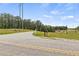 A street view showing the entrance to a property with surrounding woods and countryside at 220 Rocky Point Rd, Covington, GA 30014