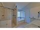 Modern bathroom featuring a tiled walk-in shower and a soaking tub beneath a window at 2800 Araglin Dr, Dacula, GA 30019