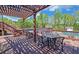 Outdoor patio area with shaded pergola, dining table and chairs, perfect for relaxing by the community pool at 2800 Araglin Dr, Dacula, GA 30019