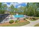 Community pool with lounge chairs and tables surrounded by a manicured lawn and mature trees at 2800 Araglin Dr, Dacula, GA 30019