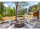 Outdoor fire pit area with seating and outdoor kitchen in a landscaped backyard at 345 Etheridge Rd, Auburn, GA 30011