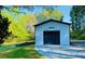 Detached garage with a modern black garage door and a well-maintained yard at 345 Etheridge Rd, Auburn, GA 30011