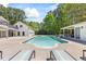 Backyard pool with mature landscaping, lounge chairs and a covered patio at 345 Etheridge Rd, Auburn, GA 30011