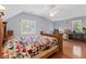 Bright bedroom boasts hardwood floors, natural light, and a quilt-covered bed for cozy relaxation at 3521 Jefferson Township Pkwy, Marietta, GA 30066