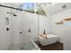 Modern bathroom with glass shower, soaking tub, and natural light at 4213 Schooner Ne Ct, Roswell, GA 30075