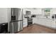 Modern kitchen boasts white cabinets, stainless steel appliances, and dark hardwood floors at 4213 Schooner Ne Ct, Roswell, GA 30075
