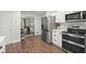 View of the eat-in kitchen with stainless appliances, white cabinets, and hardwood floors at 4213 Schooner Ne Ct, Roswell, GA 30075
