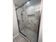 Modern bathroom showcasing glass shower doors, stylish tile work, rainfall shower head, and chrome grab bars at 7260 Dunhill Ter, Atlanta, GA 30328