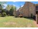Well-maintained backyard featuring a lush lawn, mature trees, and the home's attractive brick facade at 3562 Langley Oaks Se Ct, Marietta, GA 30067