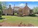Expansive backyard view of a brick home with a covered patio, lush lawn, and meticulous landscaping at 3562 Langley Oaks Se Ct, Marietta, GA 30067