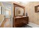 Bathroom with a wooden vanity with dual sinks, a framed mirror, and decorative wallpaper at 3562 Langley Oaks Se Ct, Marietta, GA 30067