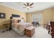 Cozy bedroom with a large window, ceiling fan, rocking chair, desk, and trunk in front of the bed at 3562 Langley Oaks Se Ct, Marietta, GA 30067