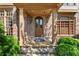 Inviting front porch with a classic arched doorway, brick facade, and manicured shrubbery at 3562 Langley Oaks Se Ct, Marietta, GA 30067
