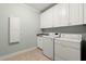 Well-equipped laundry room featuring tile flooring, ample cabinet space, and modern appliances at 3562 Langley Oaks Se Ct, Marietta, GA 30067