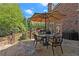 Inviting outdoor patio featuring stone floors, seating under an umbrella, and views of the landscaped backyard at 3562 Langley Oaks Se Ct, Marietta, GA 30067