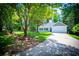 Inviting home featuring a well-maintained lawn, mature trees, an attached two-car garage, and a paved driveway at 4694 E Glen Ridge E Cir, Winston, GA 30187