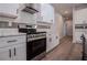 Modern kitchen featuring stainless steel appliances, sleek white cabinets, and tiled backsplash at 4694 E Glen Ridge E Cir, Winston, GA 30187