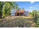 Exterior view of a backyard with a deck, partially fenced yard, and mature trees offering shade at 5399 Kristian Ct, Stone Mountain, GA 30088