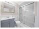 Bathroom with a glass enclosed tiled shower, blue vanity and framed mirror at 5399 Kristian Ct, Stone Mountain, GA 30088