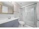 Modern bathroom featuring white marble tile, shower with glass doors, and a gray vanity with top-mounted sink at 5399 Kristian Ct, Stone Mountain, GA 30088