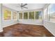 Sunroom filled with natural light from multiple windows and complete with ceiling fan and hardwood flooring at 5399 Kristian Ct, Stone Mountain, GA 30088