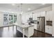 Open kitchen with stainless steel appliances, white cabinets, gas range, and hardwood floors at 687 Avondale Creek Dr, Decatur, GA 30032