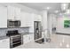 Kitchen with stainless steel appliances, white cabinets, gas range, and subway tile backsplash at 687 Avondale Creek Dr, Decatur, GA 30032