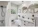 Bright bathroom featuring a shower/tub combo, window, and double sinks at 1110 Tuxedo Dr, Roswell, GA 30075