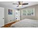 Bedroom features hardwood floors, a ceiling fan, natural light, and ensuite half-bathroom with stylish black and white tile flooring at 1110 Tuxedo Dr, Roswell, GA 30075