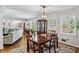 Elegant dining room with a classic chandelier, hardwood floors, and ample natural light from the windows at 1110 Tuxedo Dr, Roswell, GA 30075