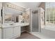 Bathroom featuring dual sink vanities, a large mirror, and a separate shower and tub at 2130 Federal Rd, Roswell, GA 30075