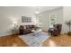 Cozy living room features hardwood floors, leather seating, and natural light from large windows at 2130 Federal Rd, Roswell, GA 30075