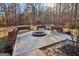 Backyard firepit with surrounding bench seating nestled in a wooded lot at 283 Rosebay Ln, Sharpsburg, GA 30277