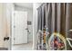 Stylish bathroom with a modern shower curtain and a glimpse into the next room at 283 Rosebay Ln, Sharpsburg, GA 30277