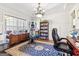 Office features an area rug, desk, and a window overlooking the front yard at 283 Rosebay Ln, Sharpsburg, GA 30277