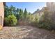 Backyard features a partially fenced yard and a wooded area, offering privacy and natural surroundings at 3704 Wilkins Cir, Powder Springs, GA 30127