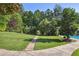 Beautiful backyard featuring a stone pathway leading through a green lawn and manicured landscaping at 3704 Wilkins Cir, Powder Springs, GA 30127