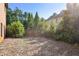 Backyard featuring a small fenced area and a patio space, surrounded by mature trees, offering a private outdoor retreat at 3704 Wilkins Cir, Powder Springs, GA 30127