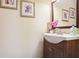A stylish powder room with an elegant sink, framed art, and a decorative flower arrangement at 3704 Wilkins Cir, Powder Springs, GA 30127