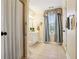 This bathroom features a tiled floor, a vanity, a window with curtains and a shower with glass doors at 3704 Wilkins Cir, Powder Springs, GA 30127